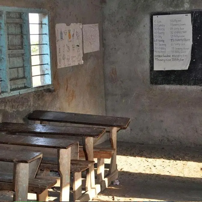 scuola primaria statale con banchi di legno vecchi ed usurati